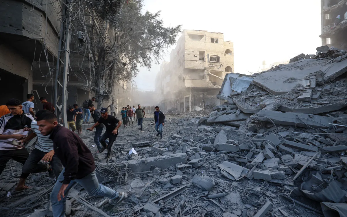 Người dân Palestine chạy tìm nơi trú ẩn sau một cuộc không kích của Israel ở trung tâm Dải Gaza, ngày 19/10/2025. (Ảnh: AFP)
